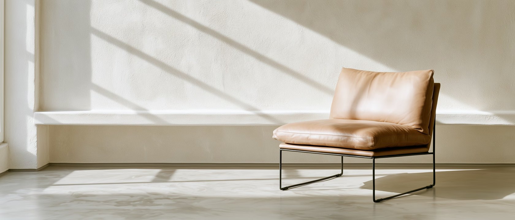 Un fauteuil en cuir clair dans une pièce baignée de lumière